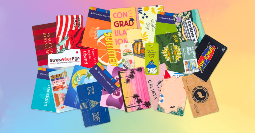 Pile of colorful library, gift, and membership cards scattered on a pastel rainbow background.